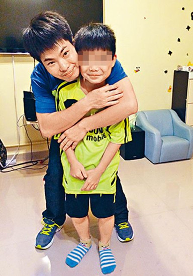 香港单亲爸爸郑欢恒在访问时合照,紧紧地揽抱儿子。图自香港《星岛日报》