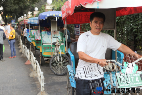 三轮车整齐排列,轮流接客,不会再挤成一团