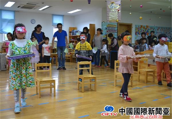 孩子们蒙上眼睛,在家长的指挥下穿过障碍运送点心.jpg