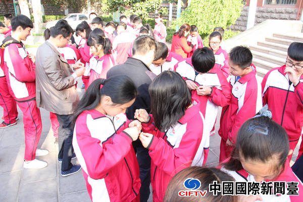班主任和老团员给新团员佩戴团徽.jpg