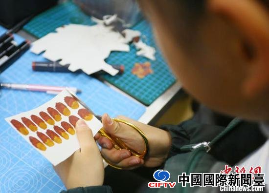 图为小学生将马克笔涂色的纸片进行裁剪。 高展 摄